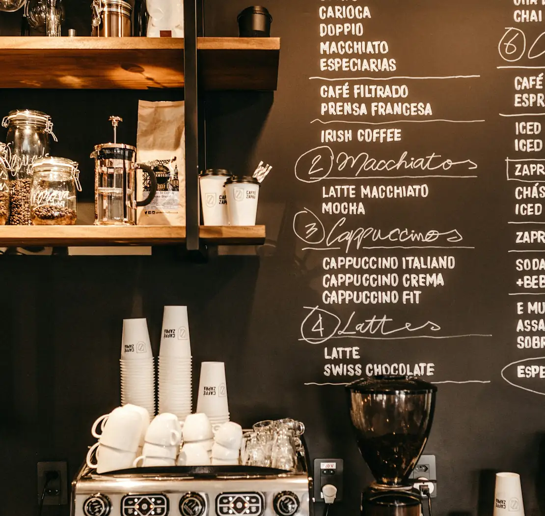 Máquina de espresso y pizarrón de menú en una cafetería